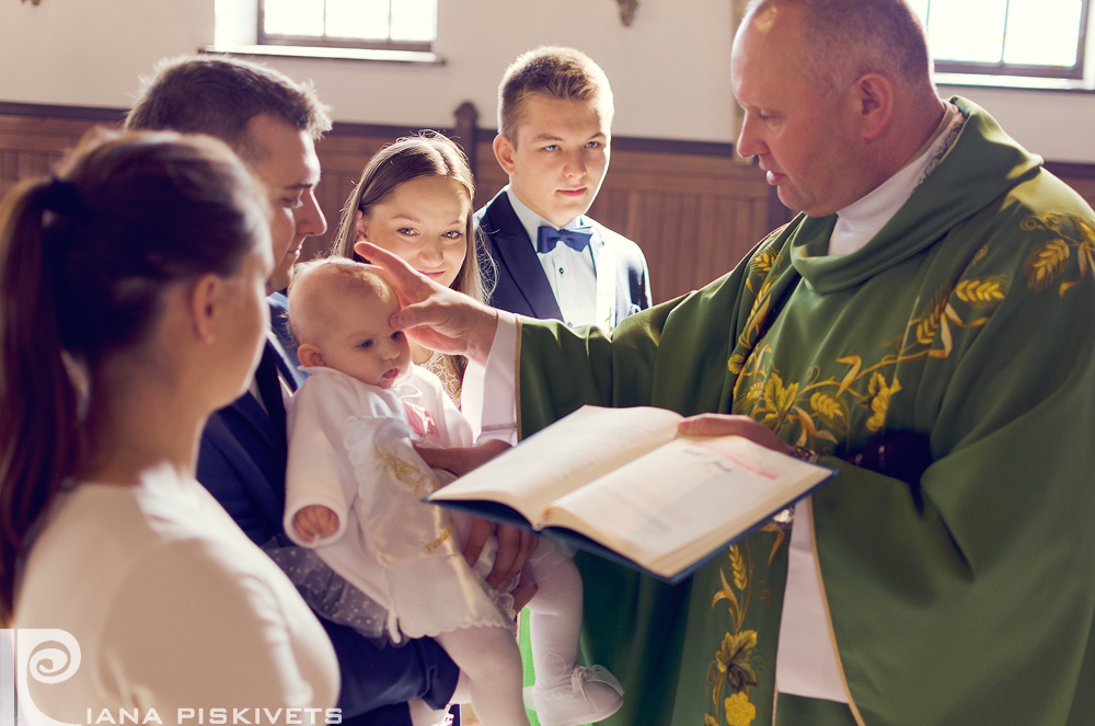 Ceremonia Chrztu Świętego to wyjątkowa i bardzo ważna uroczystość dla dziecka, rodziców oraz rodziny. Oprócz przygotowania duchowego, warto również przygotować się na współpracę z fotografem, dzięki czemu wykonane przeze mnie fotografie z Waszą pomocą, będą wspaniałą pamiątką. Poradnik stworzyłem na podstawie własnych doświadczeń i obserwacji wielu Chrztów świętych.    PRZYGOTOWANIE  – ekspresja, luz, swobodne zachowanie; – bez pośpiechu; – to jest Wasz i Waszego dziecka dzień i wy jesteście jego reżyserami, nie pozwólcie, aby stres Was opanował; – w domu jest czas na fotografowanie detali – bucików, ubranka, świecy, szatki oraz innych osobistych rzeczy – dobrze, aby były dostępne dla fotografa; – zadbajcie o to, aby tam, gdzie będzie ubieranie i będą robione zdjęcia nie znajdowały się niepotrzebne ciuchy, pudełka, reklamówki, wieszaki itp.  KOŚCIÓŁ – dobrze byłoby wcześniej na spotkaniu z księdzem wspomnieć, że będziecie mieli swojego fotografa (posiadam wymagane zaświadczenie z kurii do fotografowania uroczystości kościelnych); – poproście gości o to, aby nie dokumentowali Chrztu Świętego własnymi aparatami, ponieważ mogą utrudnić lub uniemożliwić mi wykonanie fotografii, podczas których momentów nie da się powtórzyć- polanie główki dziecka wodą święconą itp. – nie szukamy niepotrzebnie wzrokiem fotografa i nie patrzymy w obiektyw, chyba że fotograf o to poprosi; – kapłan podchodzi i kreśli na czole dziecka znak krzyża, trzymajcie dziecko przodem do niego jak na zdjęciu poniżej;  – znak krzyża na czole dziecka rodzice i chrzestni powinni robić kciukiem z zaciśniętą pięścią, tak by nie zasłonić za bardzo twarzy dziecka, żeby fotograf mógł to uwiecznić; – polewanie główki dziecka to jeden z ważniejszych momentów, miejcie na myśli fotografa i nie odwracajcie się w ostatniej chwili do niego z dzieckiem plecami; – dobrze jest podczas mszy trzymać dziecko na kolanach, na zmianę rodzice i chrzestni – fotograf będzie miał możliwość zrobić ładne i naturalne zdjęcia; – po mszy jest okazja, by przed ołtarzem zrobić zdjęcie grupowe wszystkich gości, jeśli chcecie takie zdjęcie, poproście zawczasu gości by po mszy nie wychodzili z kościoła;  – jeśli koło kościoła jest park albo miejsce zacienione z ładnym tłem gdzie można zrobić mini sesję dziecka z gośćmi, to możemy je wykorzystać do zdjęć po lub przed mszą.   PRZYJĘCIE – w przypadku wykonywania fotografii rodzinnej, jeżeli nie ma możliwości zrobienia jej w kościele, wykonuje je po przyjeździe do miejsca, w którym będzie odbywało się przyjęcie. Dziecko nie jest wtedy zbyt zmęczone i chętnie uśmiecha się na rękach rodziców; – w czasie trwania przyjęcia wykonuję fotografie rodzinne i jeżeli rodzice na to pozwolą każdy z gości ma wykonaną fotografie z maluszkiem; – przez czas mojej obecności na przyjęciu, jestem w 100% do Waszej dyspozycji- warto poinformować gości, że nie muszą brać ze sobą aparatów; – jeśli zdjęcia rodzinne z dzieckiem robimy podczas przyjęcia, najlepiej zrobić je od razu po dotarciu do restauracji/sali, dziecko będzie jeszcze mniej zmęczone; – podczas przyjęcia jestem do Waszej i Waszych gości dyspozycji i z wielką chęcią zrobię zdjęcia, o jakie poprosicie; – jeśli chcecie, abym uwieczniła tort, to zaplanujcie go tak, by był podany w czasie, w którym będę jeszcze z Wami, a jeśli tort macie później to mogę sam tort sfotografować wcześniej. Zachęcam do skorzystania z moich usług. Fotografuję chrzty na terenie Warszawy, odbywające się zarówno w czasie, jak i po mszy. Proponuję także niezapomniane fotografie z przygotowań dziecka na chrzest, podczas przyjęcia, a także sesje w plenerze. Jeśli szukacie Państwo profesjonalnego fotografa na chrzest z Warszawy, zapraszam do kontaktu.  Zachowaj wspomnienia dla swojej pociechy. Zamów pamiątkę chrztu. Fotograf na chrzest w Warszawie.  Podoba Ci się ten post? Podziel się jego treścią z innymi!