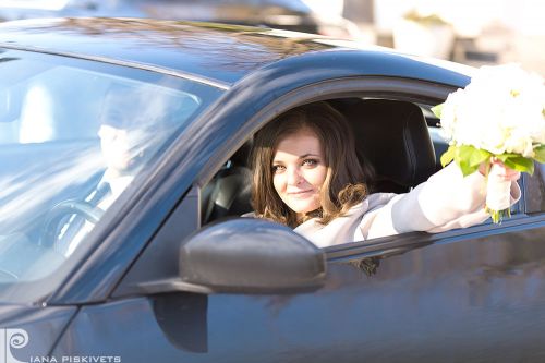 Newlyweds in a car, a beautiful woman with flowers, wedding car, bride's bouquet, a photo shoot in Warsaw, a white wedding dress, romantic photo shoot. Professional wedding photographer in Poland registrar in Pruszkow bride with a bouquet.