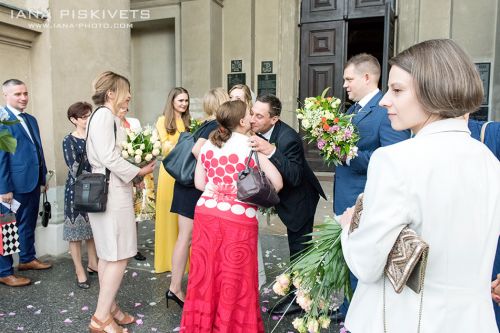 Счастливые жених и невеста с гостями возле костела. Хлопушки, цветы, подарки и поздравления родных и близких друзей, общая фотография возле костела. Профессиональный фото репортаж с венчания Варшава, Польша. Профессиональный свадебный фотограф в Варшаве.