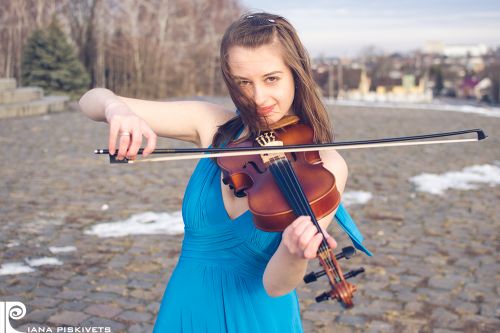 Artystyczna fotografia, pomysły na sesje zdjęciowe z instrumentami. Kobieta skrzypek w niebieskiej sukience, granatowa sukienka.  Fotograf w Warszawie. Profesjonalna fotografia - Warszawa. Sesje zimowe w plenerze. Kobieta w sukni cyjan posiada skrzypce i 